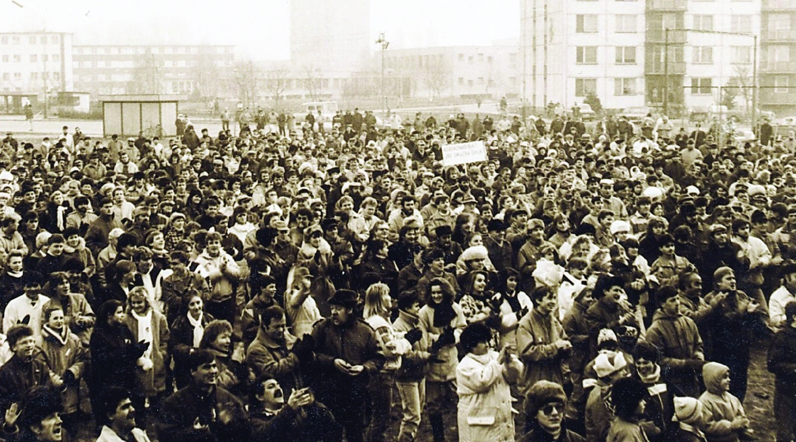 Dav ľudí na zhromaždení pri dome kultúry v Šali (červeno tónovaná fotografia)